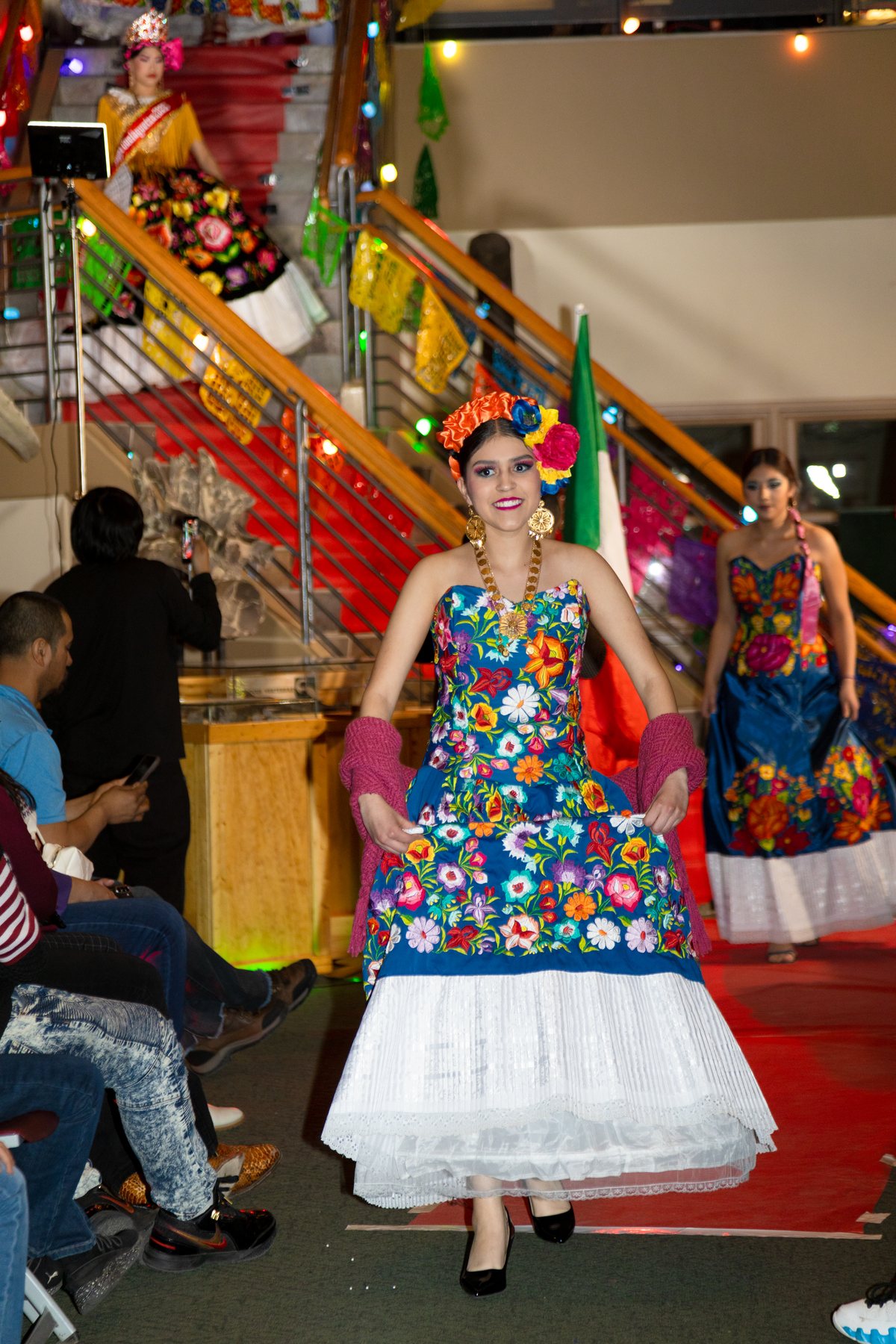 Una participante recorre la pasarela con corpiño floral azul y falda blanca