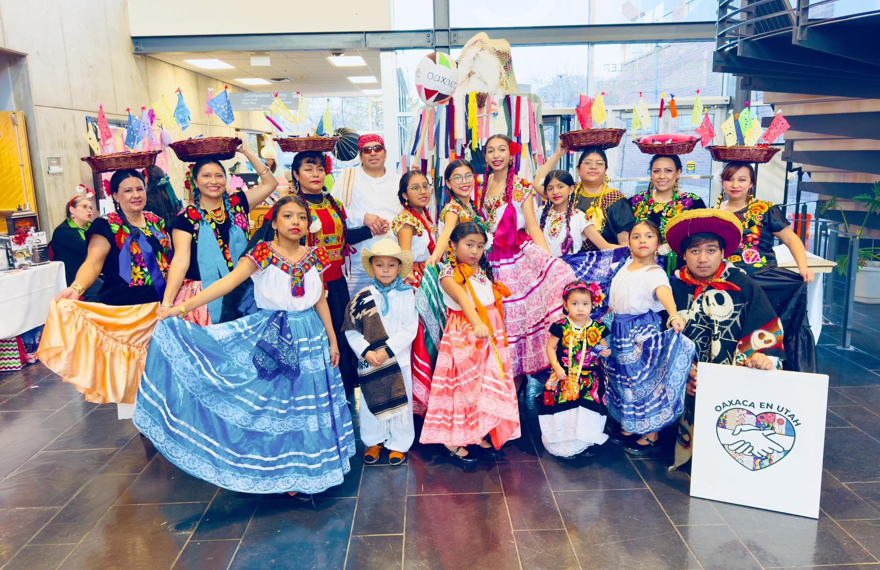 Un grupo numeroso con vestimenta colorida se reúne para un retrato interior