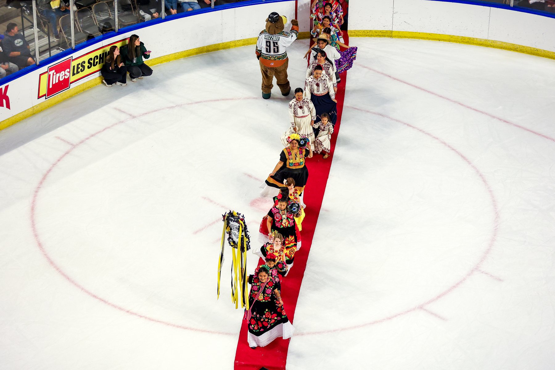 Participantes forman una larga fila sobre la alfombra roja que cruza el hielo