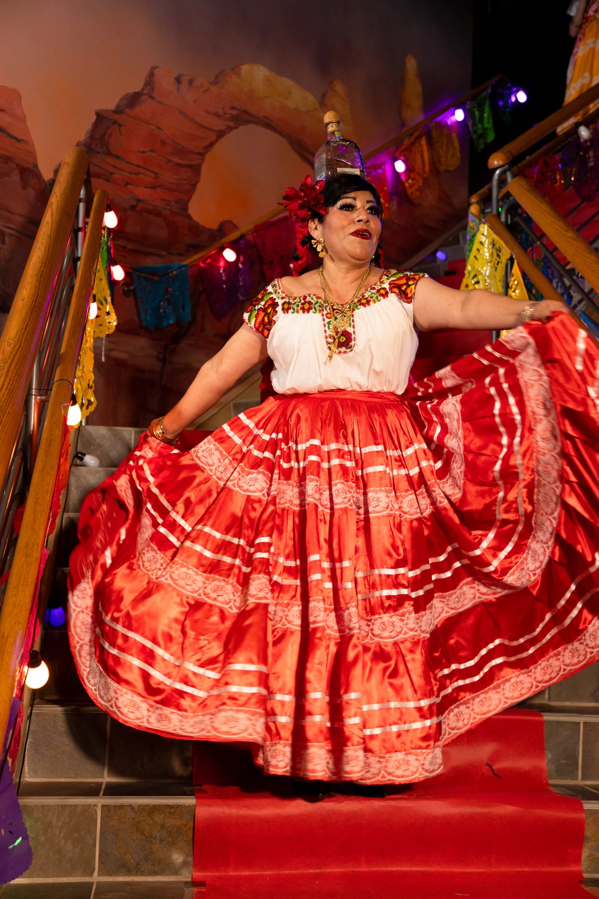 Una participante extiende una falda roja estampada sobre la escalera roja