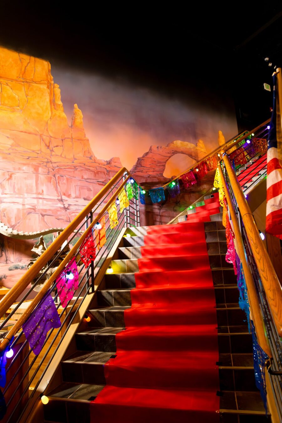 Red carpet and multicolored papel picado decorate the staircase inside Ogden Dinosaur Park